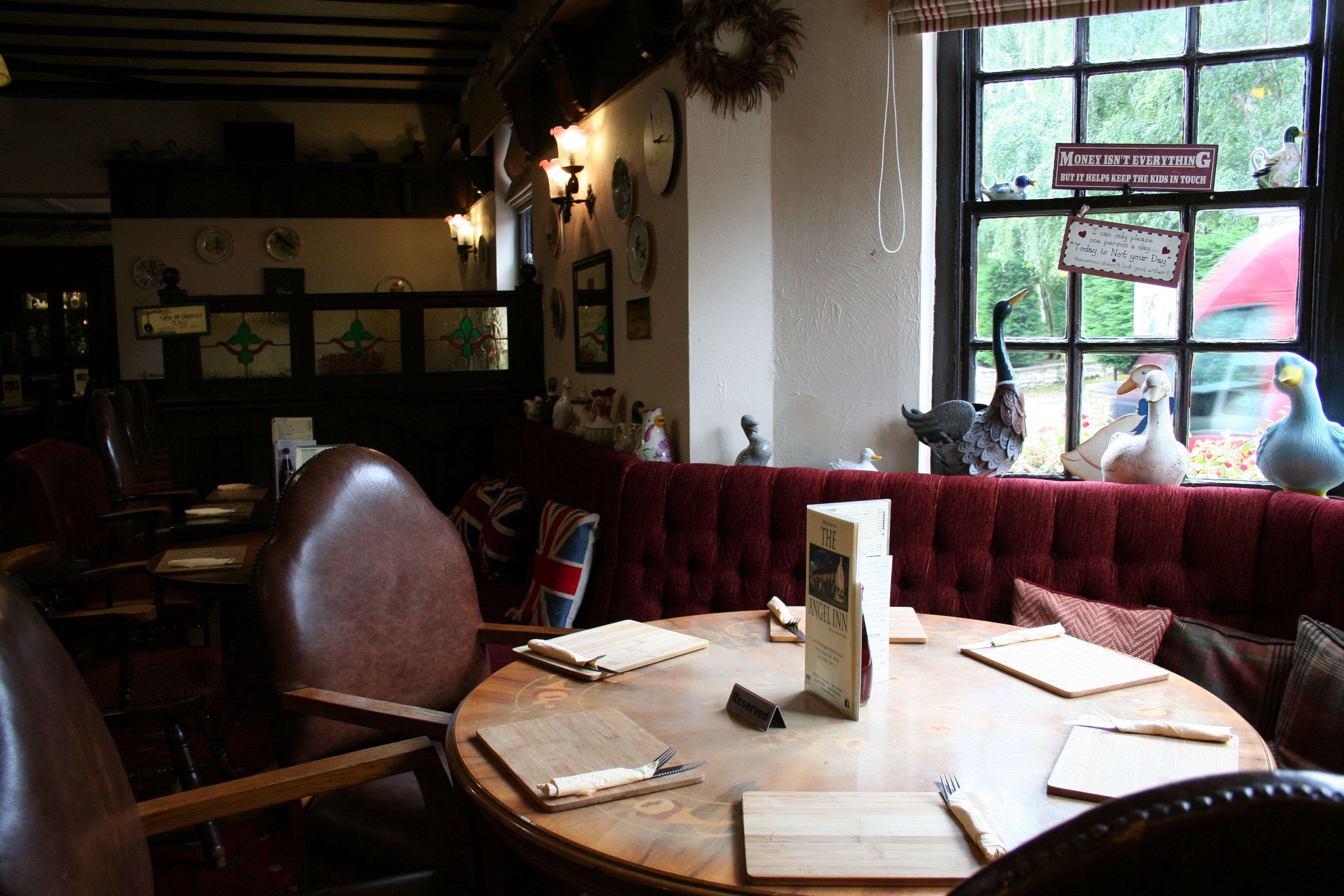 Ein gemütliches Restaurant mit Holztischen, rot gepolsterten Sitzplätzen und dekorativen Wandobjekten.