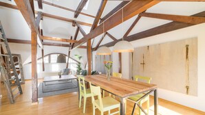 A dining area with a wooden table, yellow chairs, and hanging pendant lights.