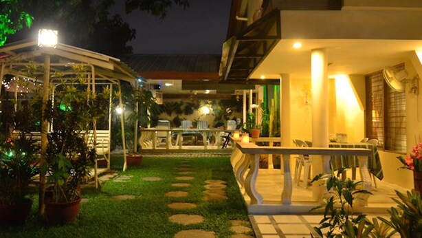 Un espace extérieur bien éclairé, doté d’une terrasse, de sièges et de plantes en pot.
