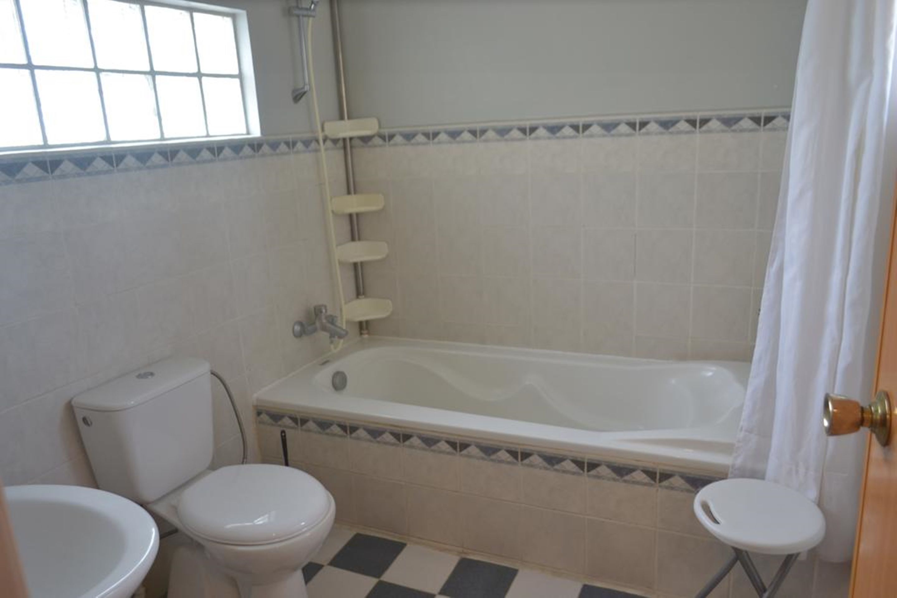 A bathroom with a bathtub, toilet, and sink.