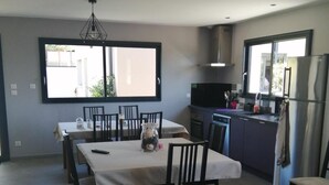 Una cocina moderna con comedor, ventanas amplias y horno empotrado.