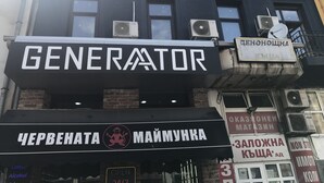 A building with multiple signs, including one for 'GENERATOR' and another for 'ЧЕРВЕНАТА МАЙМУХКА'.