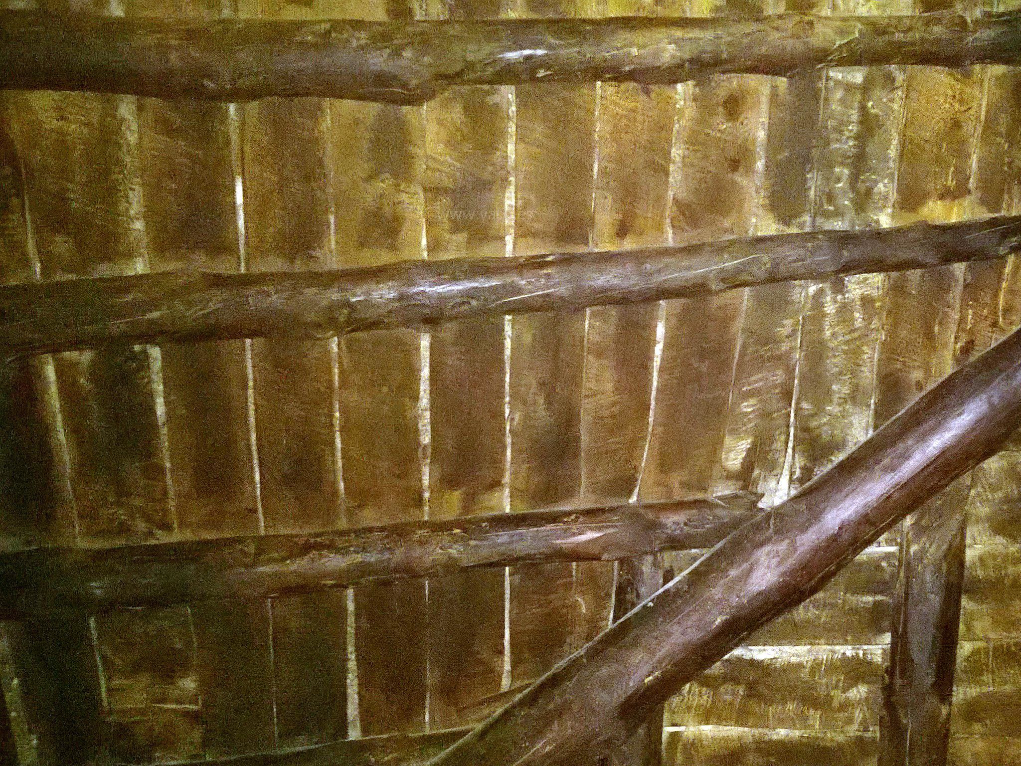 Primer plano de una estructura de madera con vigas horizontales y soportes diagonales.