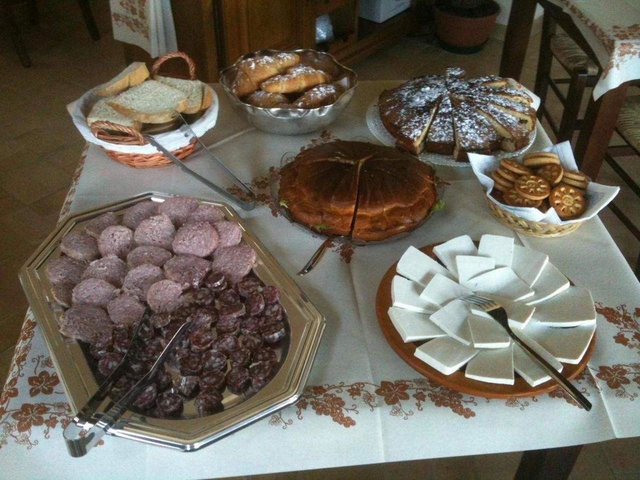 Ein Buffet mit verschiedenen Speisen, darunter Brot, Gebäck und Kuchen.