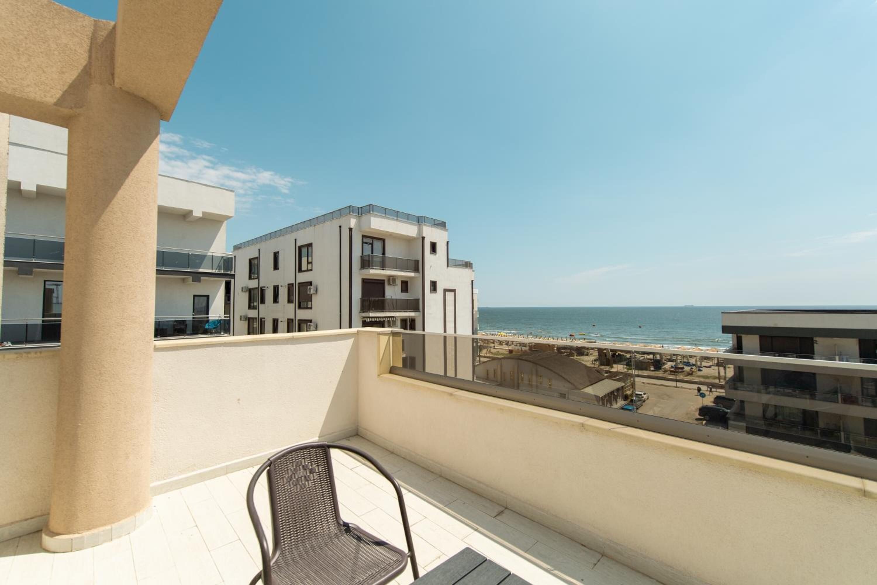Un balcón con vista a la playa y edificios.