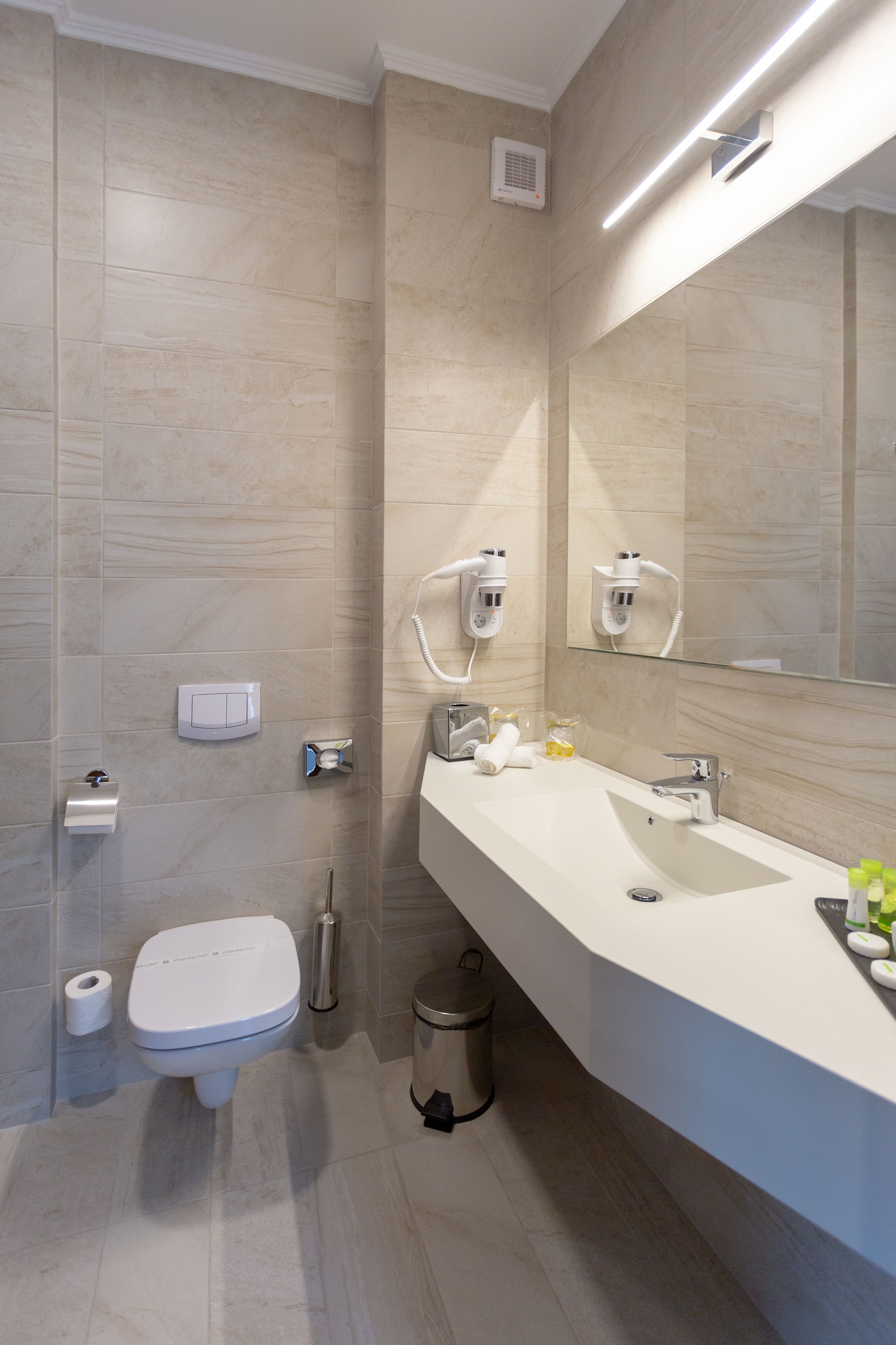 A modern bathroom with a toilet, bidet, and sink.