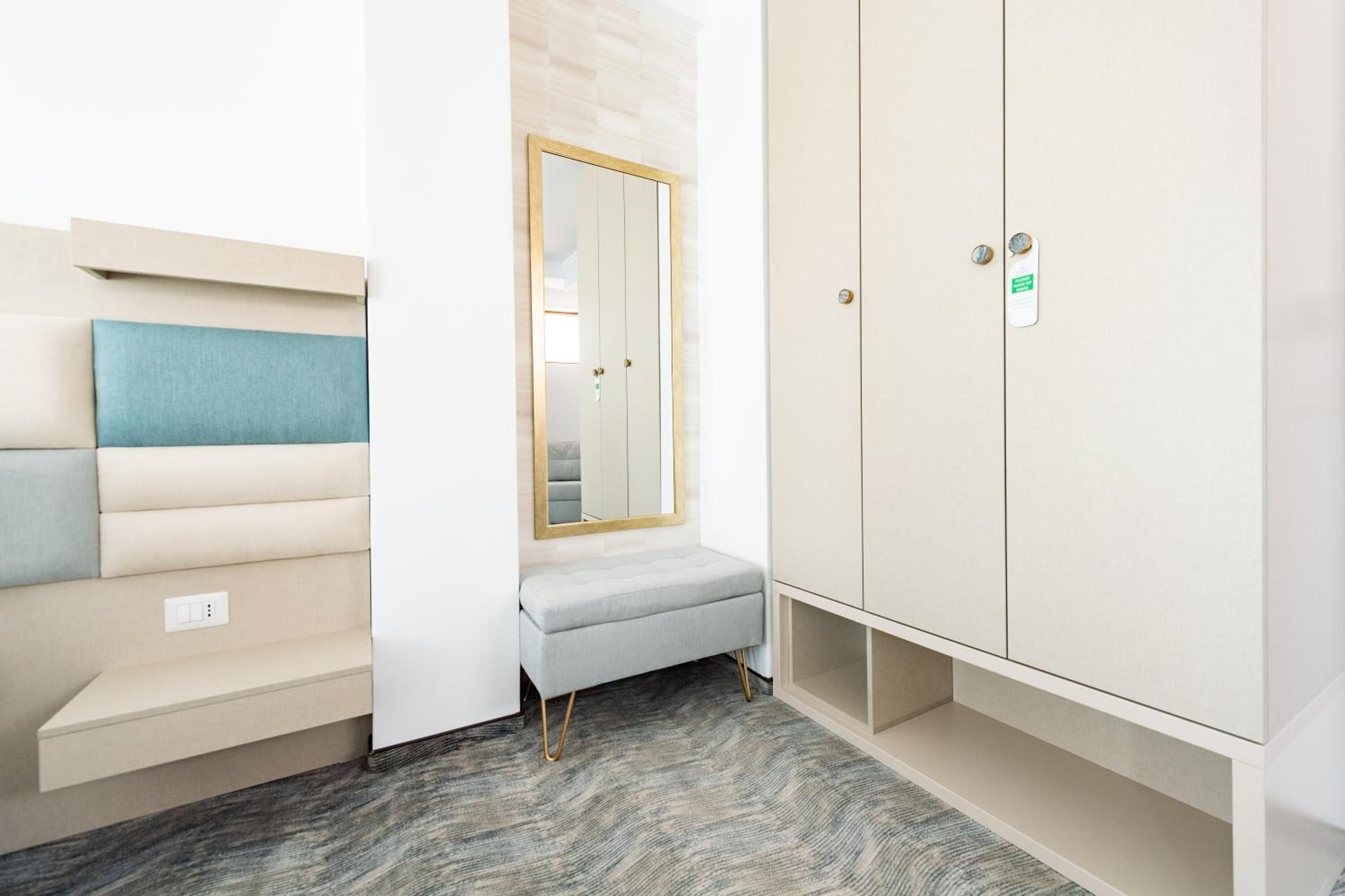 Une pièce dotée d’une banquette intégrée, d’une armoire et d’un miroir.