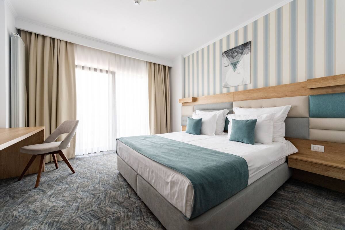 Habitació d'hotel amb un llit, escriptori i una cadira.