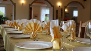 A dining table set with white plates, cutlery, and glassware, adorned with folded napkins and a small candle centerpiece. - Hotel Al Lago (Folgaria)