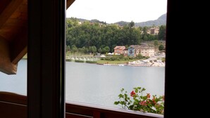 A view of a lake with buildings and greenery in the background. - Hotel Al Lago (Folgaria)