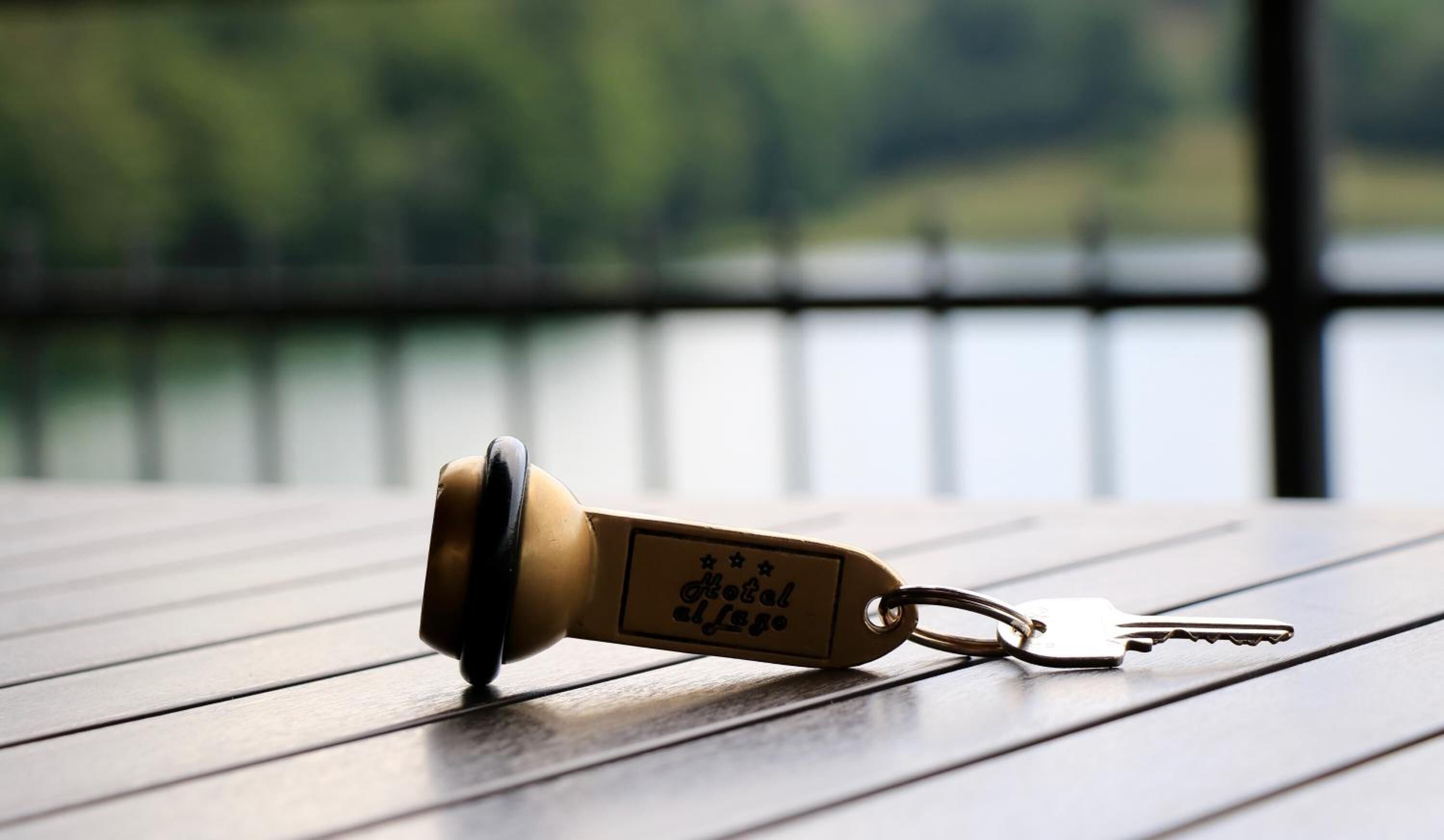 A keychain with a hotel logo on a wooden table.