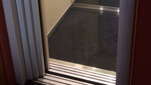An elevator interior with a control panel, a metallic floor, and a striped floor mat. - B&B Al 16 (Legnago)