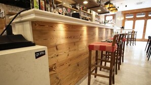 A bar area with a wooden counter and bar stools. - B&B Al 16 (Legnago)
