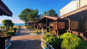 Un sendero lleva a construcciones de madera con vista al mar.