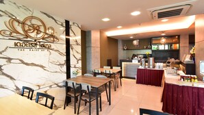 A hotel dining area with marble walls, a reception desk, and a buffet setup. - The U-Time Hotel (Hat Yai)