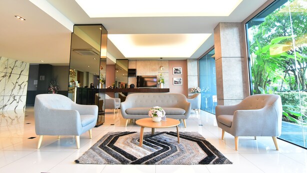 A modern living room with a sofa, armchairs, and a coffee table. - The U-Time Hotel (Hat Yai)