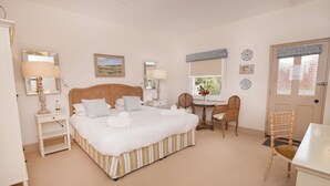 Ein Schlafzimmer mit einem großen Bett, Nachttischen, einem Schreibtisch und einem Stuhl.