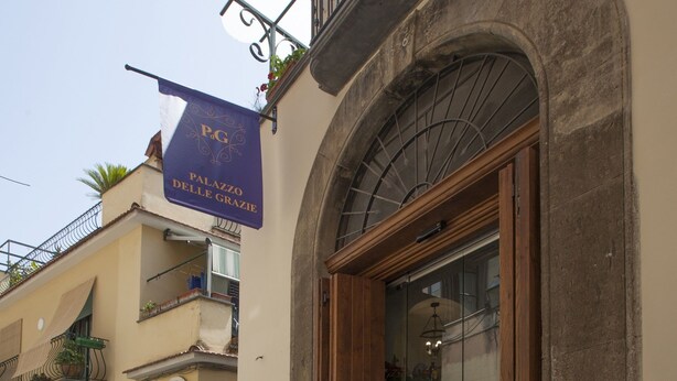 Un bâtiment doté d’une façade en pierre, d’une porte en bois et d’un balcon orné d’une rambarde en métal.