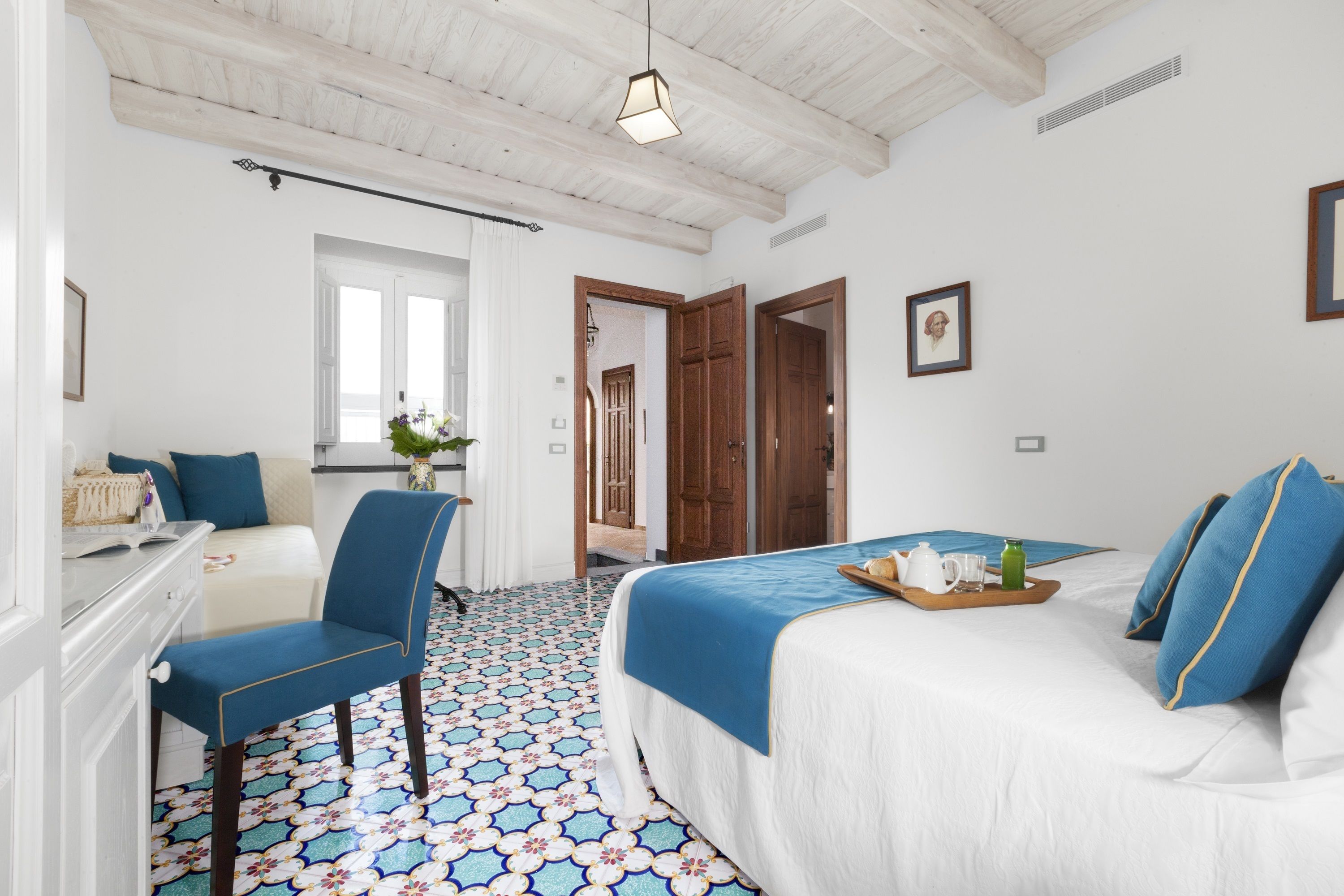 Une chambre d’hôtel avec un lit, une chaise, un bureau et une fenêtre.