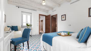 Une chambre d’hôtel avec un lit, une chaise, un bureau et une fenêtre.