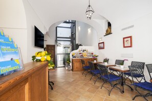 Eine moderne Hotellobby mit einer Rezeption, einer Sitzecke und einer Treppe zum Obergeschoss.