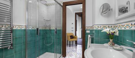 A modern bathroom with a glass-enclosed shower, a large bathtub, and a sink.