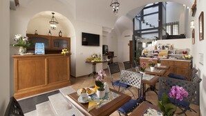 Un vaste espace de vie comprenant un coin repas avec une table et des chaises en bois, et une cuisine en arrière-plan.