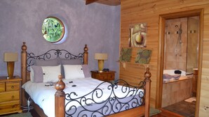A wooden-paneled bedroom with a four-poster bed, a round window, and a shower area. - Whispering Spirit Holiday Cottages (Franklin)