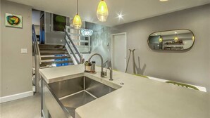 Placa de cocina, lavavajillas, utensilios de cocina y mesa de comedor