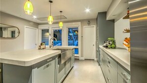 Placa de cocina, lavavajillas, utensilios de cocina y mesa de comedor