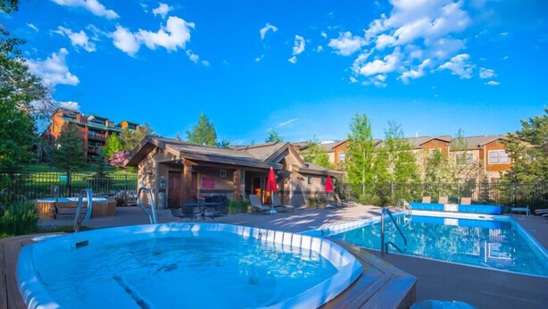 A hot tub and a pool in a resort setting with wooden deck and outdoor seating. - Moraine 1588 (Steamboat Springs)