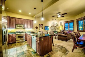 Een kookplaat, een vaatwasser, kookgerei, borden en bestek, eettafels