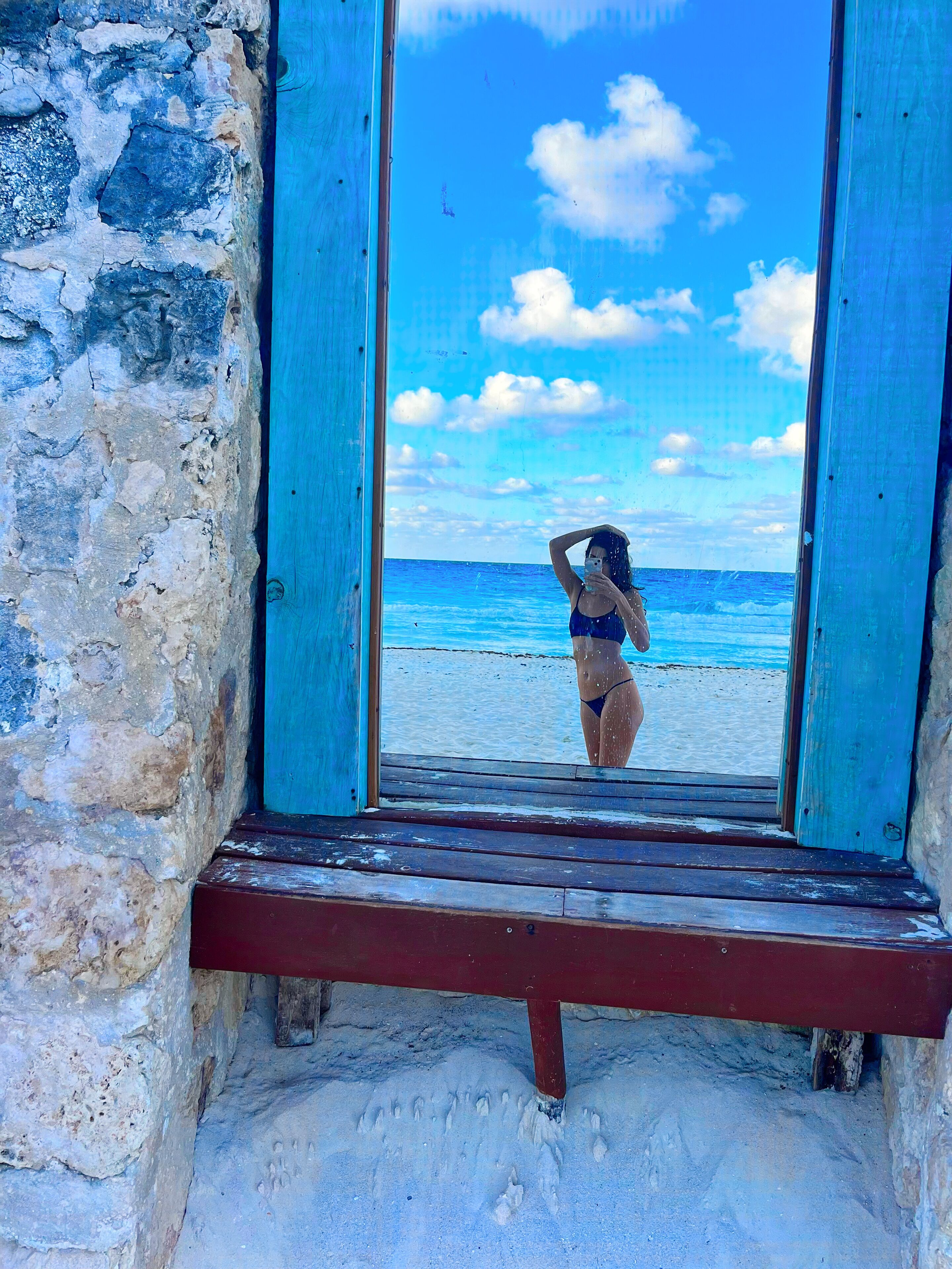 Una ventana con vista a la playa y al océano.