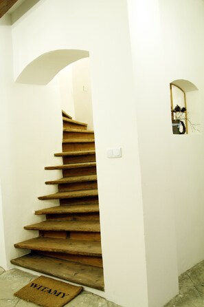 A wooden staircase with a doormat labeled "WITAMY" at the bottom. - BioRezydencja (Swieradow-Zdroj)