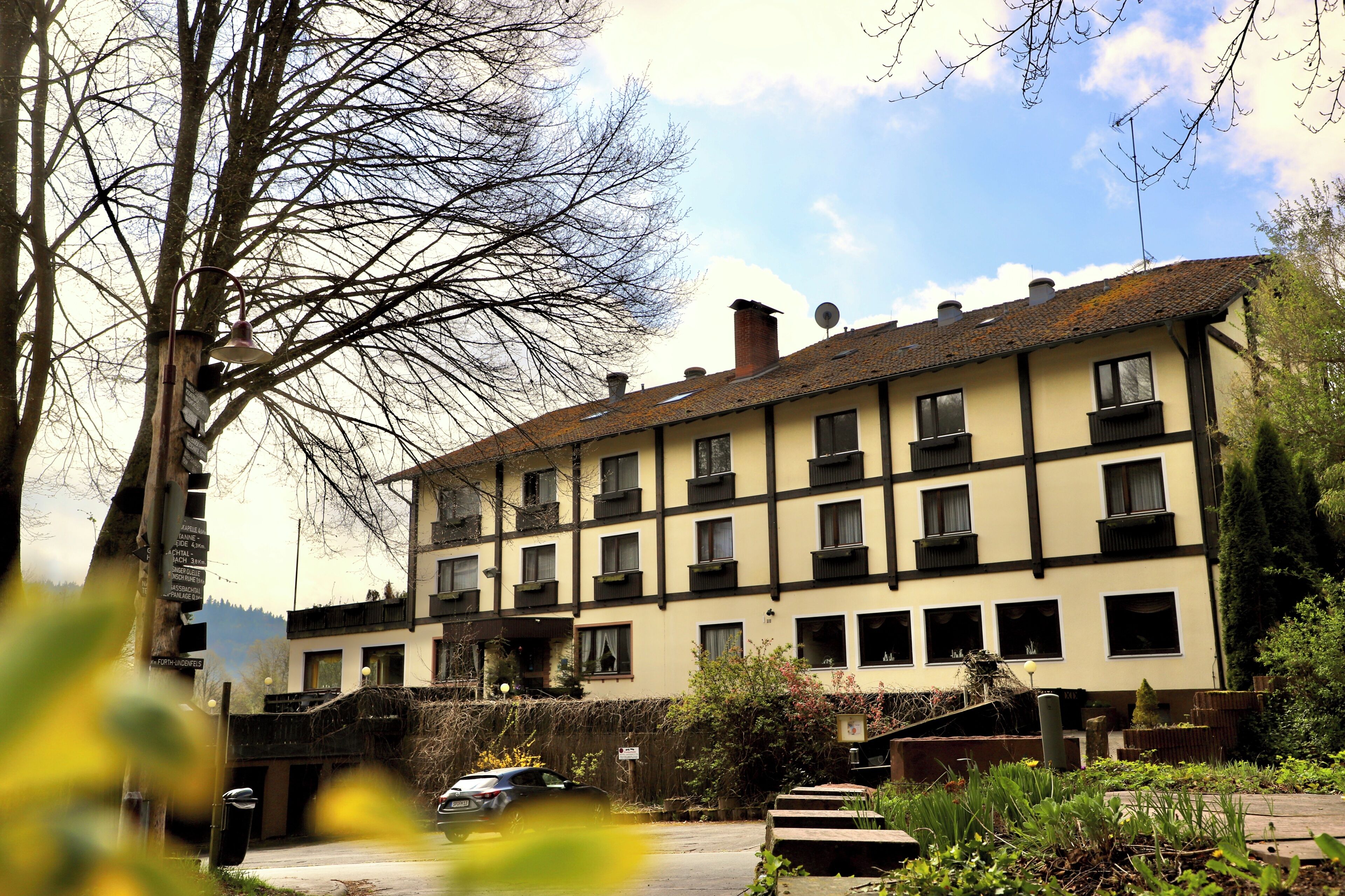 A multi-story building with a traditional architectural style, featuring a symmetrical facade with evenly spaced windows and a central chimney.