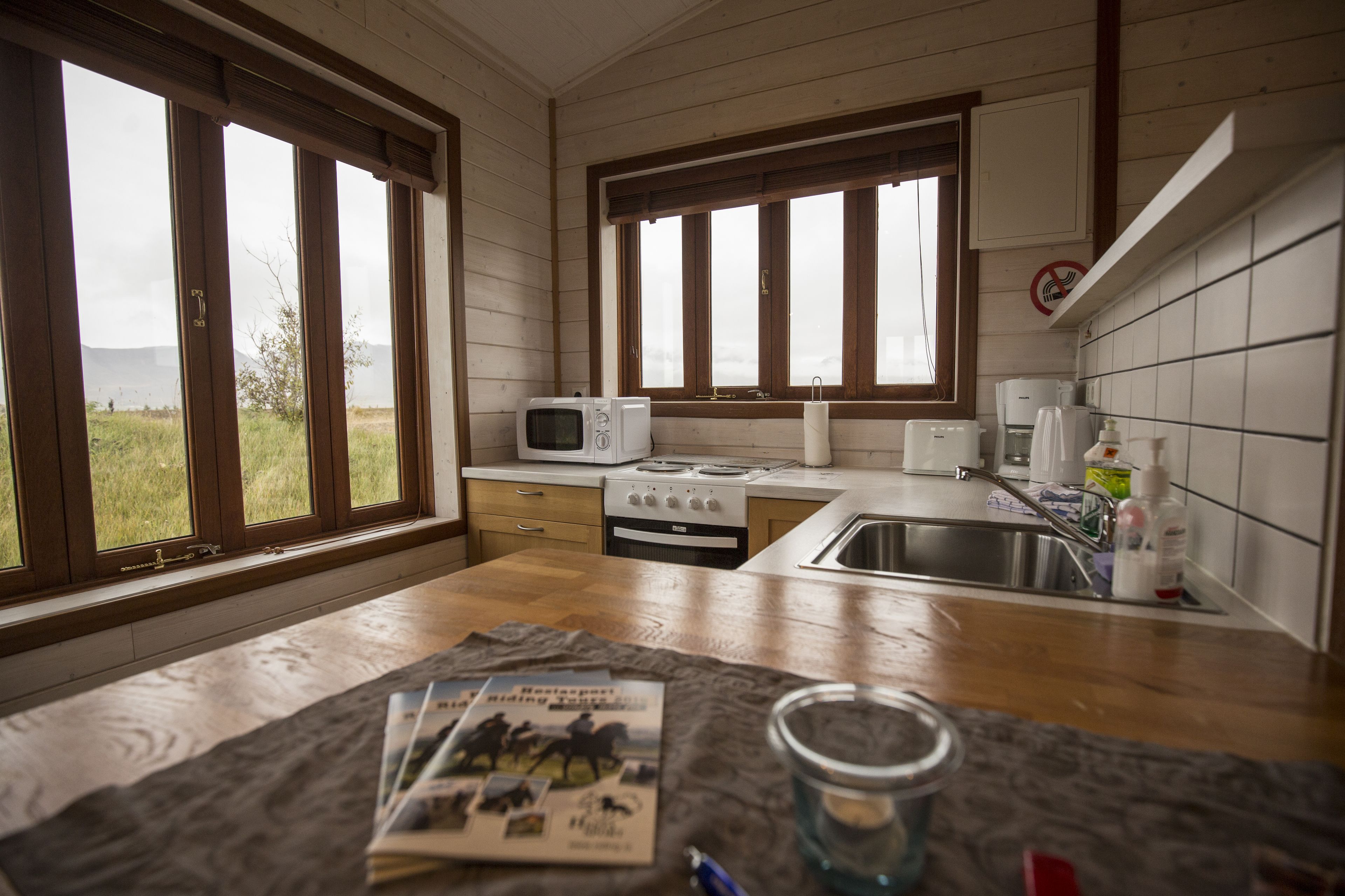 Una cocina con armarios de madera, un microondas, una estufa y un lavabo.