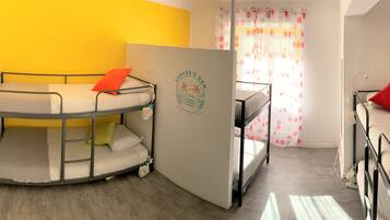 A room with bunk beds, a door with a logo, and a window with curtains.
