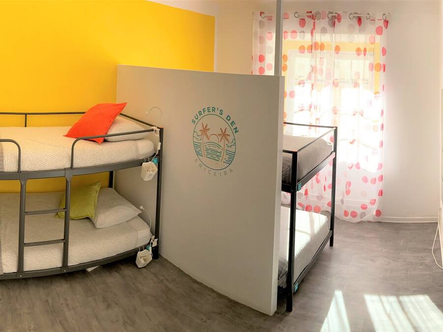 A room with bunk beds, a door with a logo, and a window with curtains.