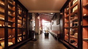A hallway with wooden shelving units on either side, displaying various items.