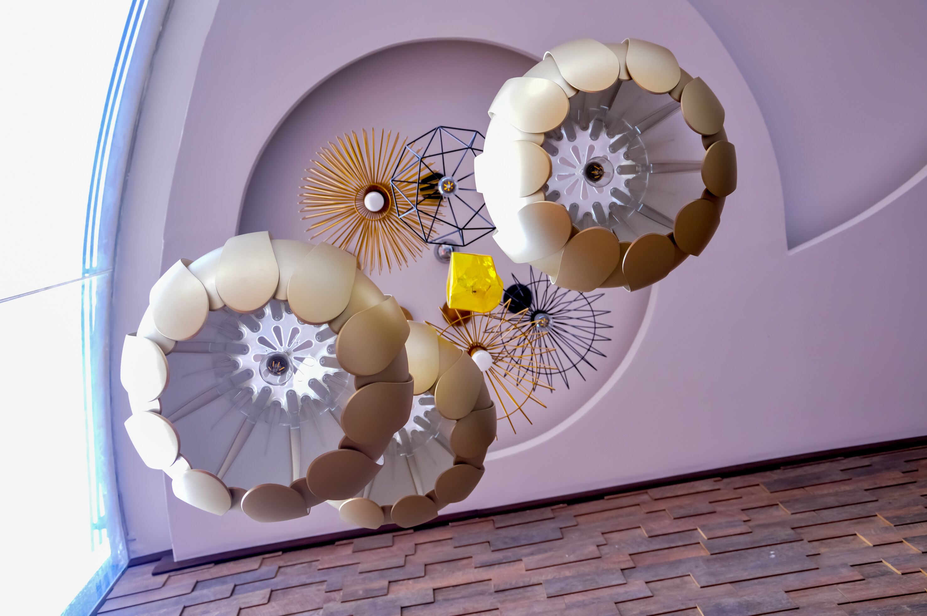 A ceiling with three spherical light fixtures and a geometric wall design.