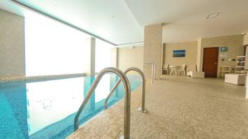 Una piscina techada, sillones reclinables de piscina