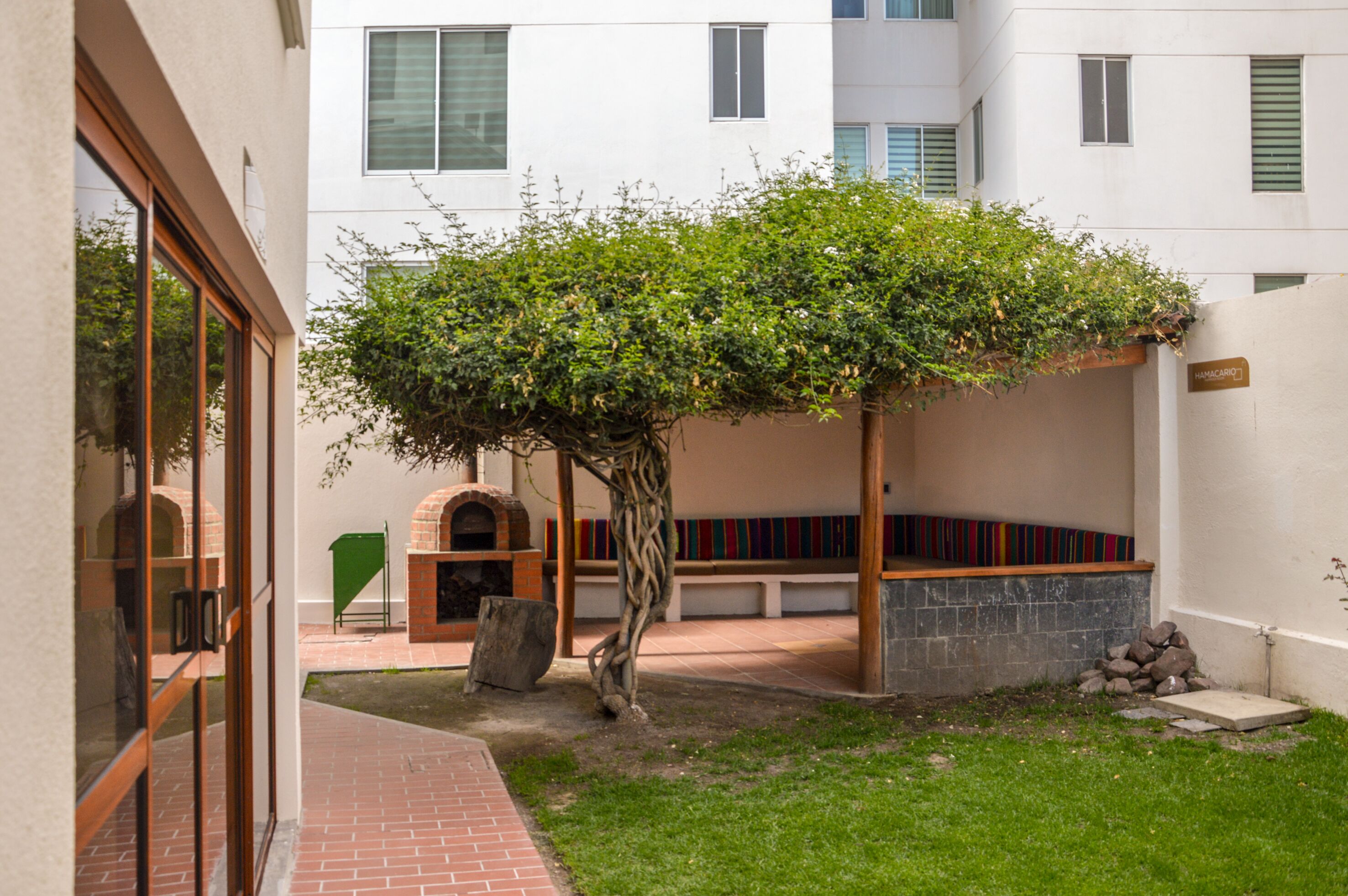 A courtyard with a tree, a bench, and a stone bench.