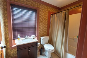 A bathroom with a toilet, sink, and shower curtain.