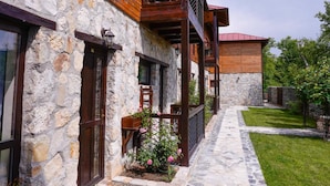A stone and wood building with a stone pathway leading to a wooden porch. - Felix Pension (Prajila)
