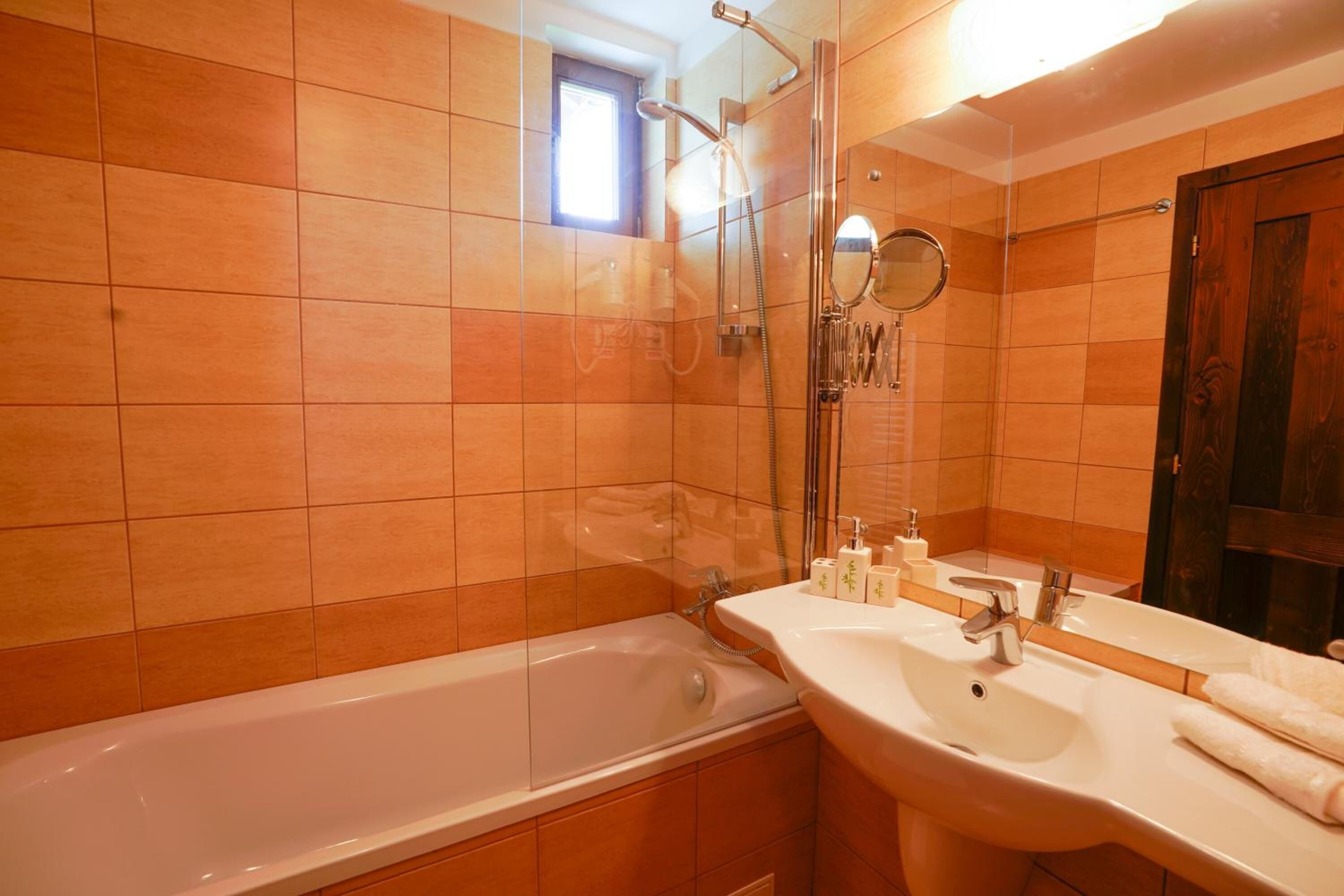 A bathroom with a bathtub, a sink, and a mirror.