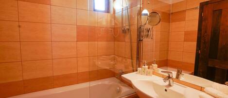 A bathroom with a bathtub, a sink, and a mirror.