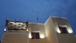 A building with a flat roof, multiple windows, and a visible antenna. - Santorini Family Apartments (Santorini)