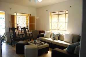 A living room with a sofa, chairs, a coffee table, and a decorative screen. - Casa Micher y Deylin (Viñales)