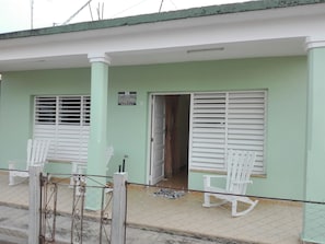 A building with a green facade, white shutters on the windows, and a sign indicating it is Villa Isabel y Luisito. - Villa Isabel y Luisito (Viñales)