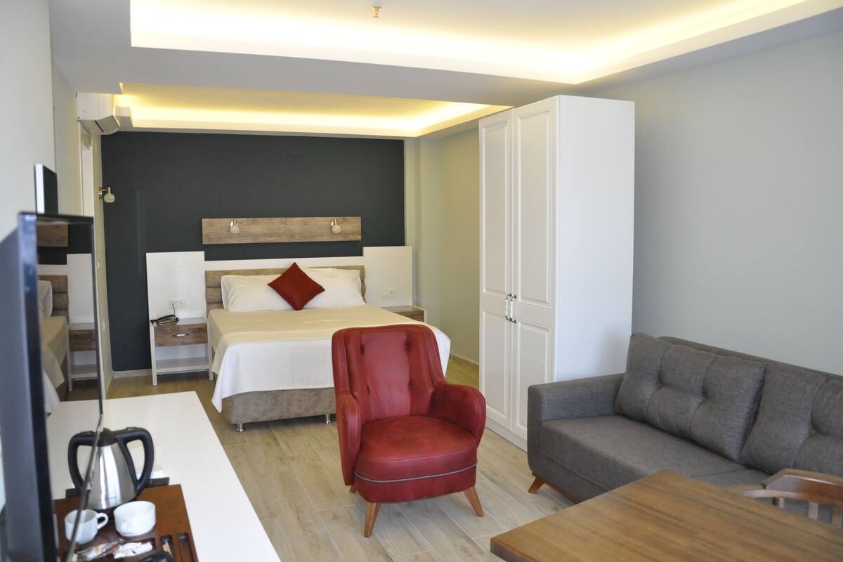 Suite Deluxe | Área de sala de estar | Televisión LCD de 82 cm con canales premium y televisión